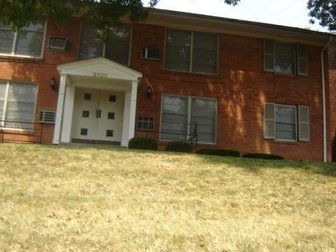 A red brick building with a white door and windows.