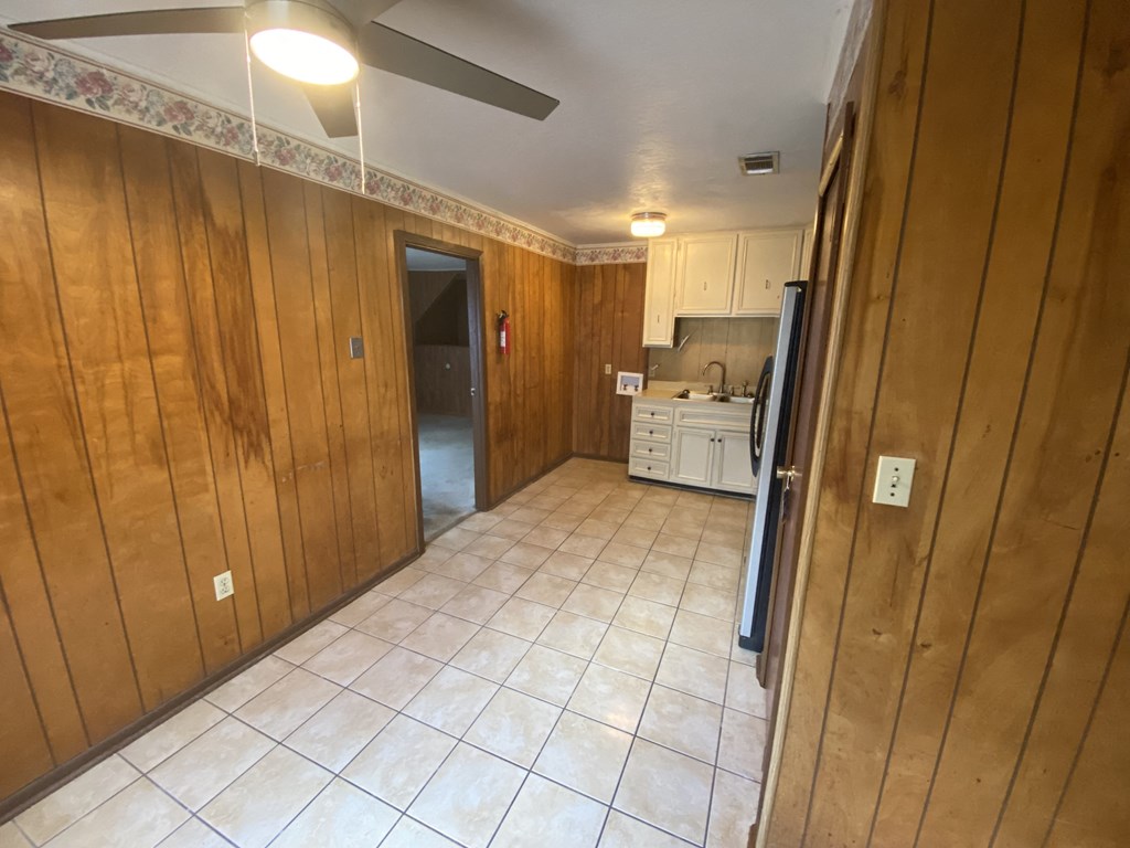 a kitchen with a tile floor and wooden walls