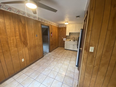 a kitchen with a tile floor and wooden walls