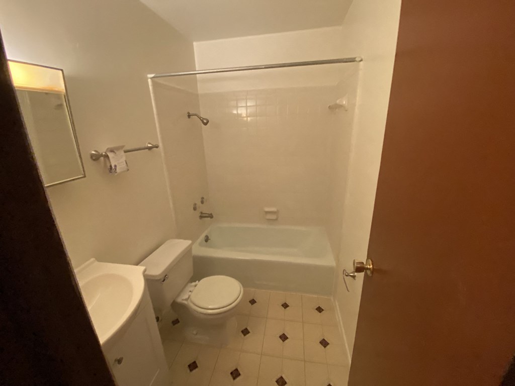 a small bathroom with a toilet and a bath tub