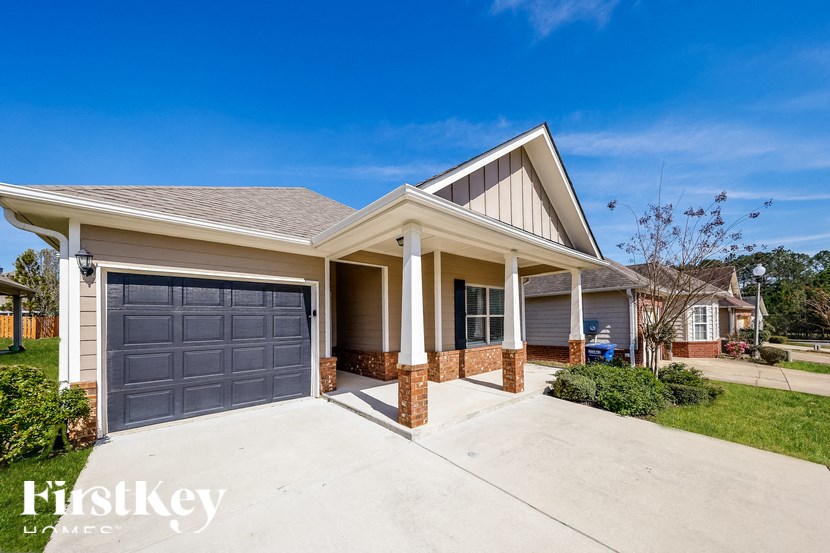 A house with a garage and a driveway in front of it.