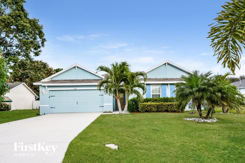 a blue house with palm trees in front of it