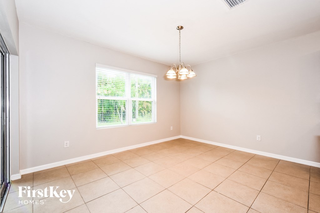 the dining room of a home with a tiled floor and a window