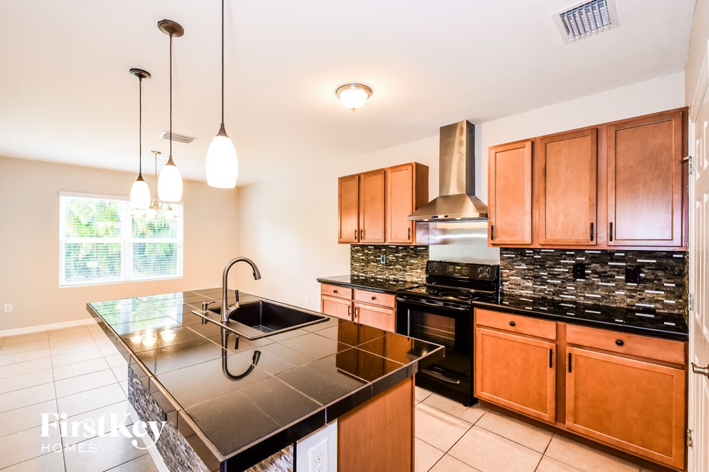 a kitchen with wooden cabinets and black counter tops and a sink