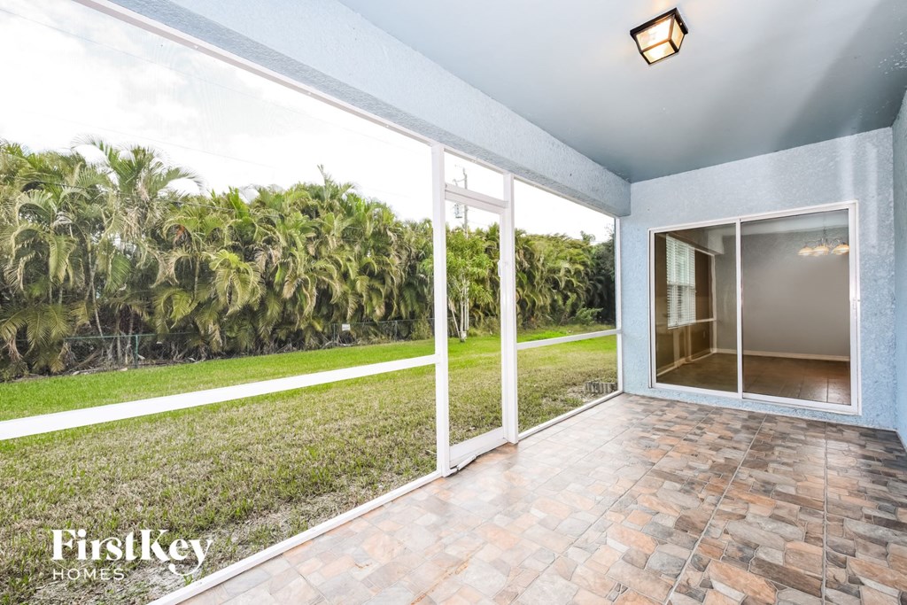 a view of the backyard of a house with glass doors and a patio
