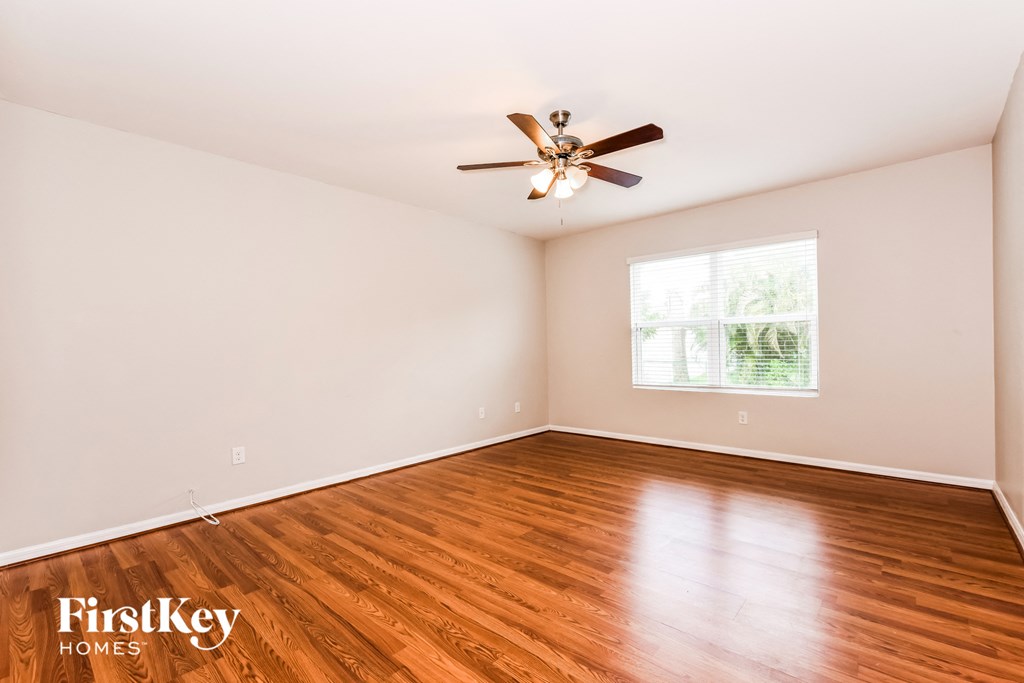 a living room with wood floors and a ceiling fan