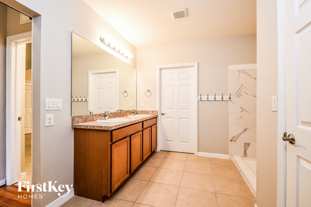 a bathroom with a sink and a shower and a mirror