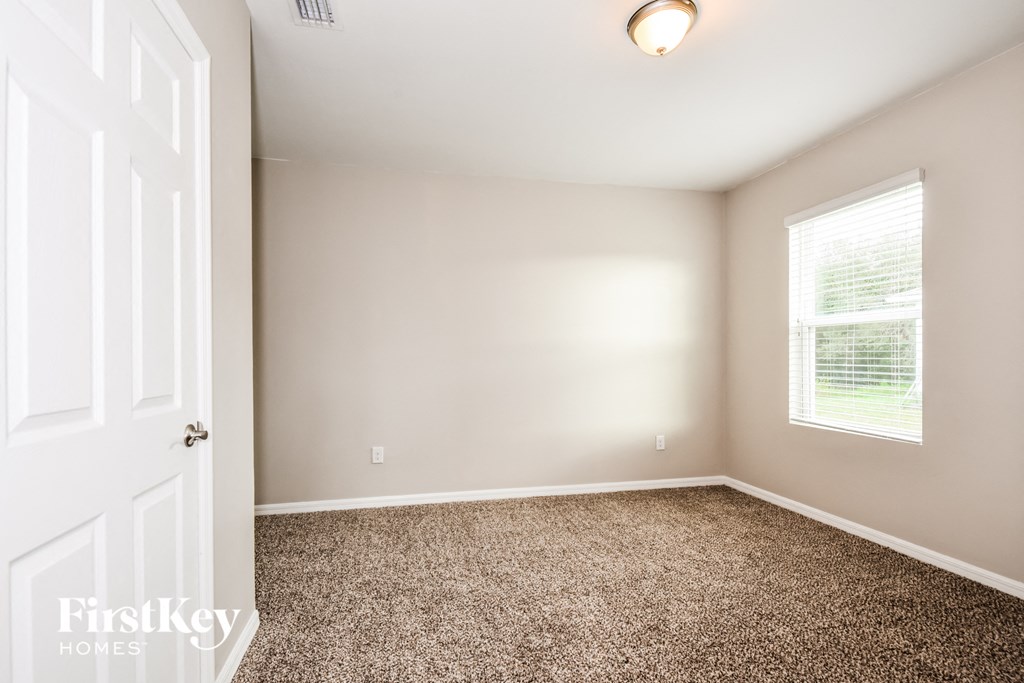 a bedroom with a carpeted floor and a window