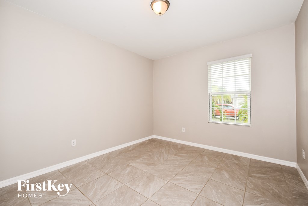 the living room of a home with a tiled floor and a window