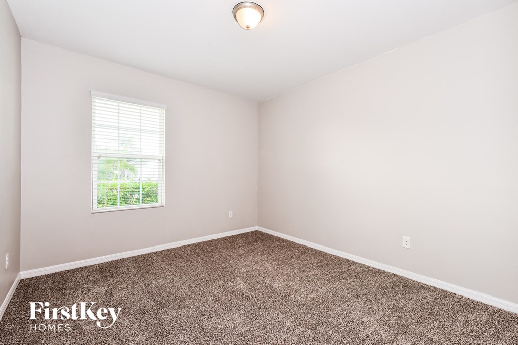 a bedroom with a carpeted floor and a window