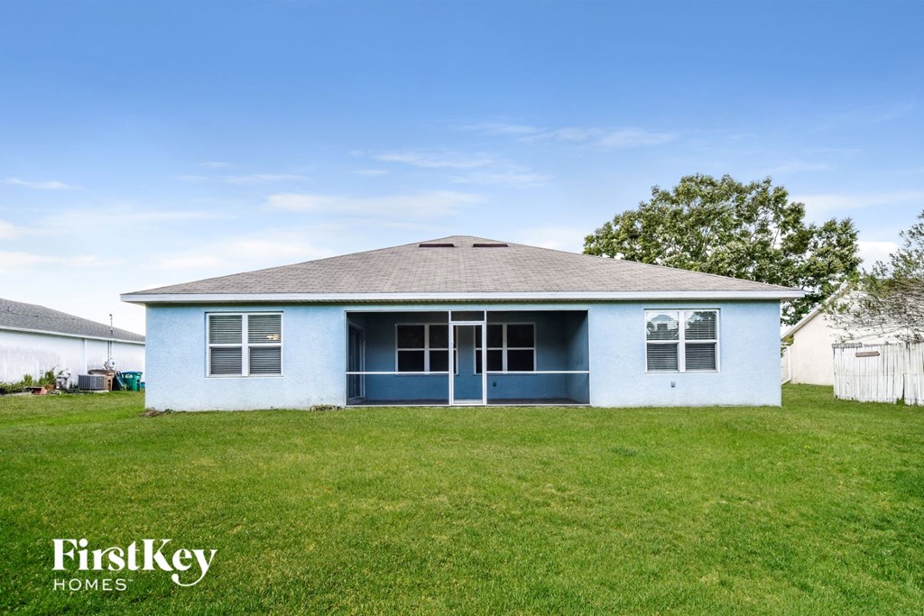 a small blue and white house in a grassy yard