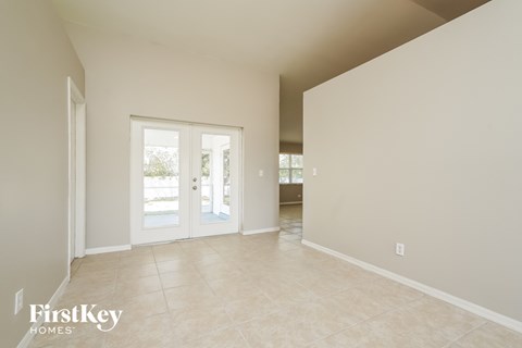 the living room and dining room of a house with white doors