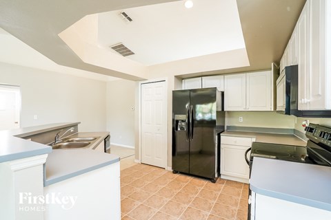 a kitchen with white cabinets and a stainless steel refrigerator