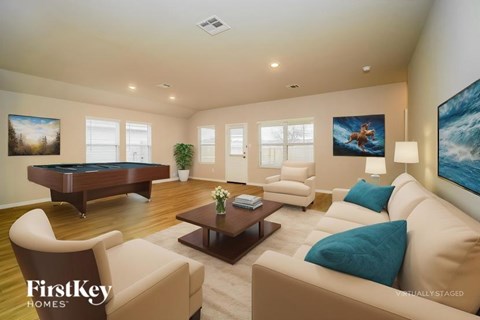 A living room with a pool table and a painting of a horse on the wall.