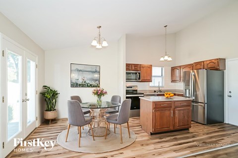A kitchen with a dining table and chairs in the middle of the room.