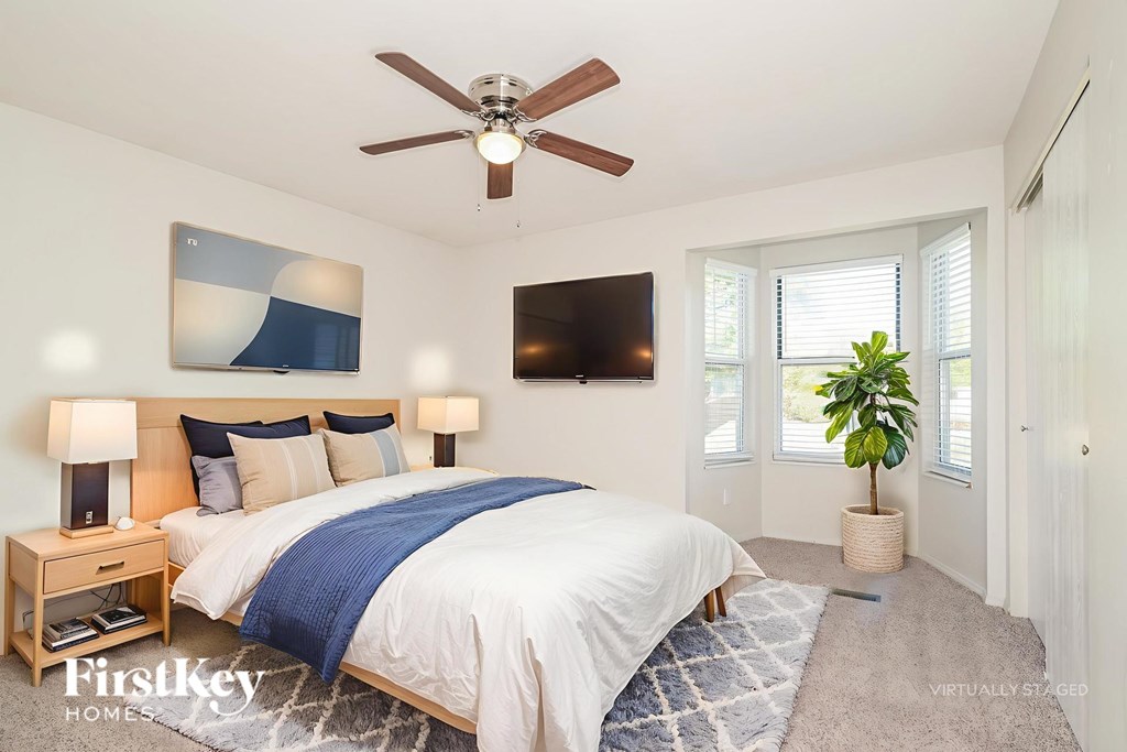 A bedroom with a large bed and a flat screen TV mounted on the wall.