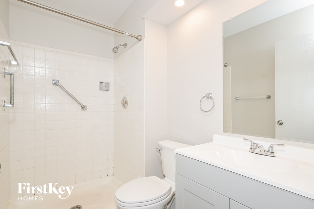 A white bathroom with a toilet, sink and shower.