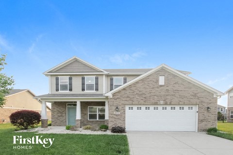 A house with a garage and a driveway in front of it.