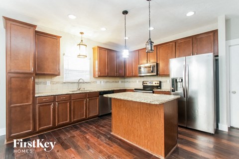 A kitchen with wooden cabinets and a granite countertop.