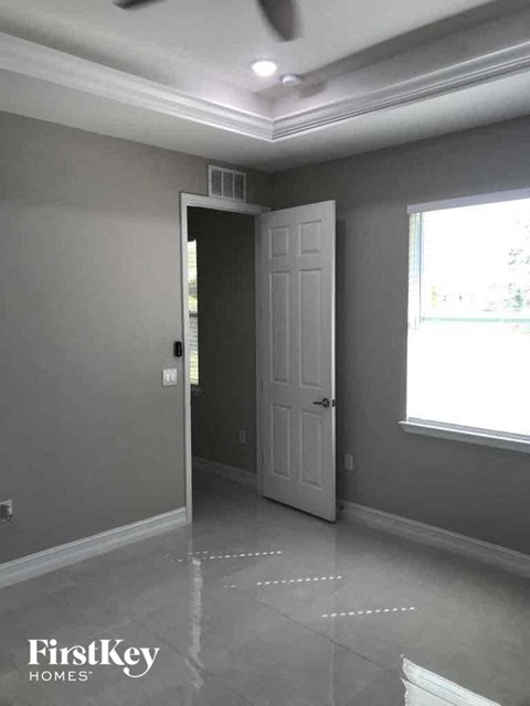 A room with a grey wall and a white door.