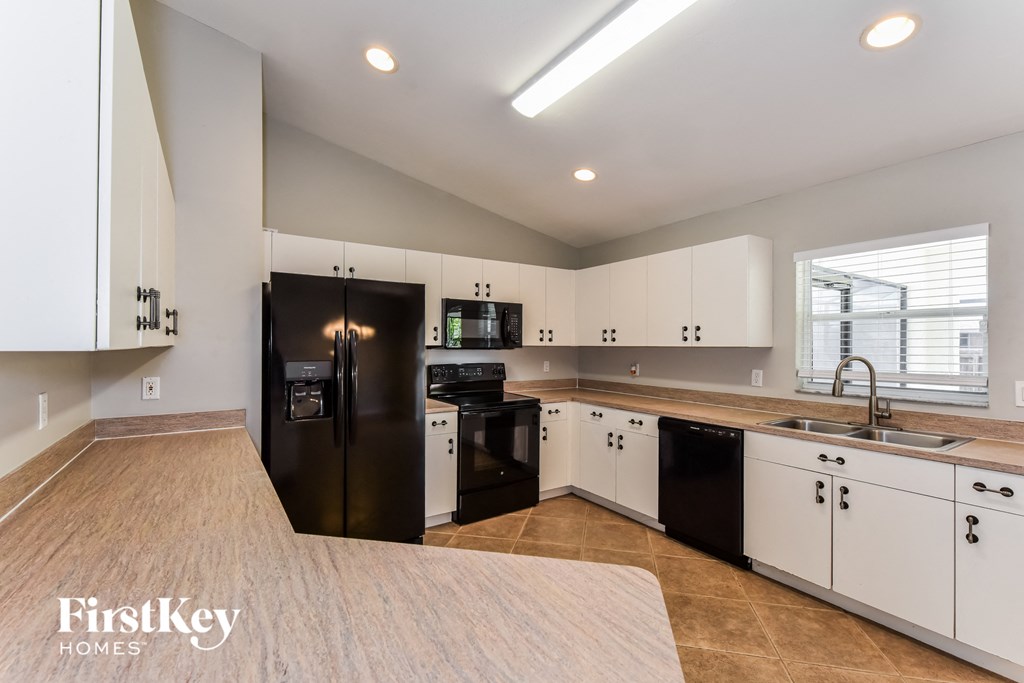 a large kitchen with black appliances and white cabinets