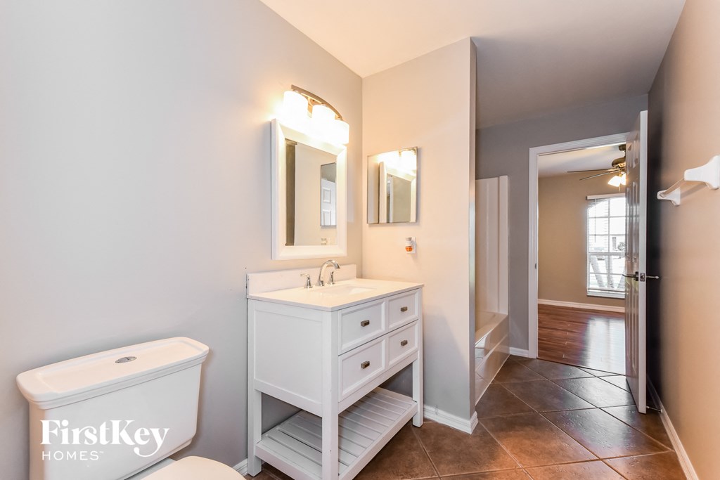 a bathroom with a white sink and toilet and a mirror