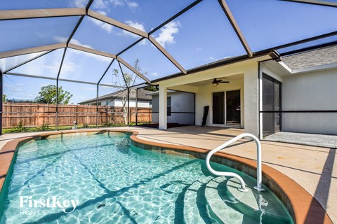 a swimming pool in a house with a patio and a pool enclosure