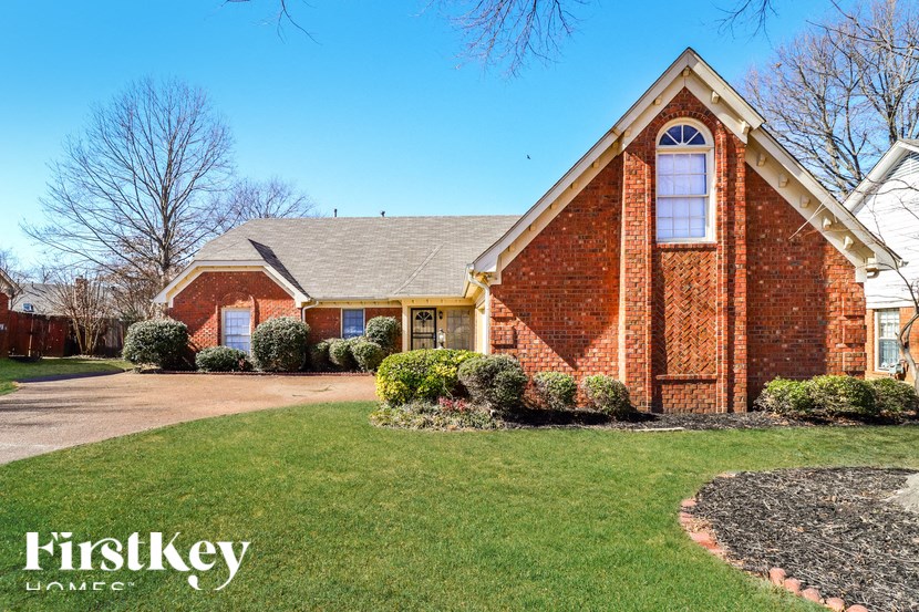 A brick house with a well-maintained lawn in front.