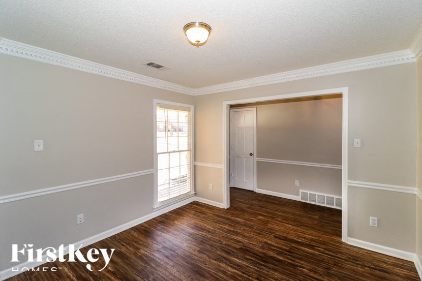 A room with a wooden floor and a white ceiling with a light fixture.