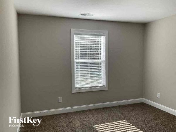 a empty room with a window and a carpet