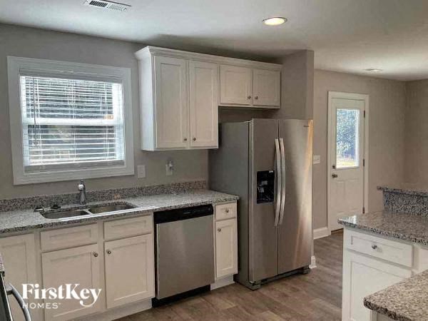 a kitchen with white cabinets and a stainless steel refrigerator