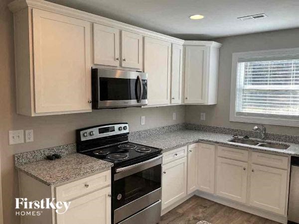 a kitchen with white cabinets and a stove and a microwave