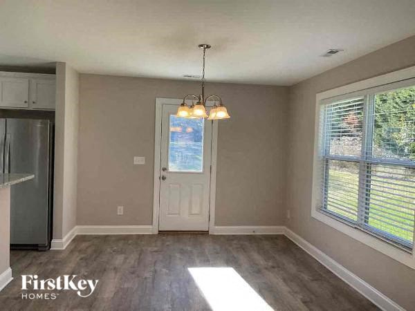 an empty living room with a white door and a window