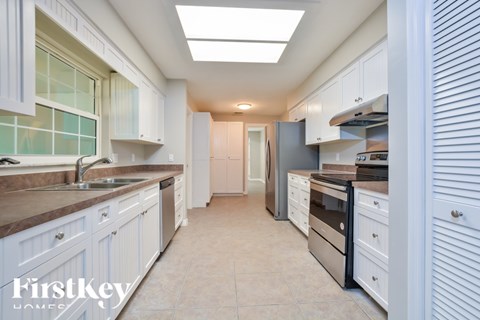 A kitchen with white cabinets and a tiled backsplash.