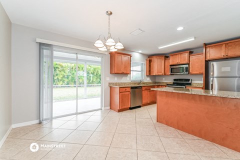 a large kitchen with wooden cabinets and stainless steel appliances