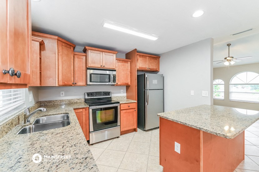 a kitchen with granite counter tops and wooden cabinets