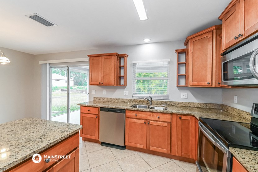 a kitchen with wooden cabinets and granite counter tops and a sink