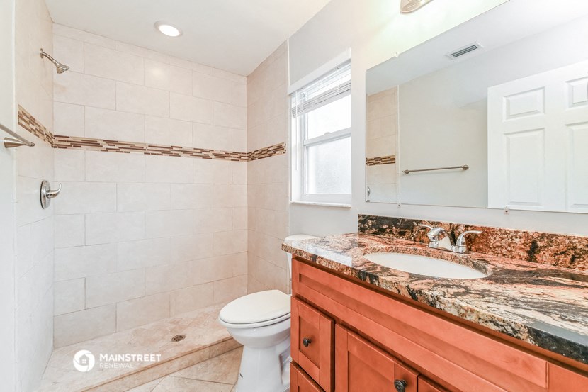 a bathroom with a toilet and a sink and a mirror