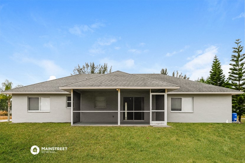 a white house with a porch and a blue sky