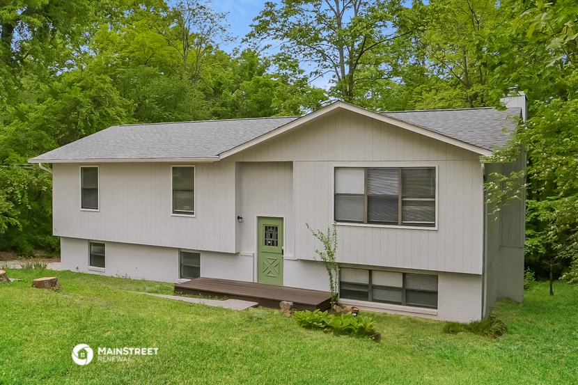 a white house with a green door and a porch