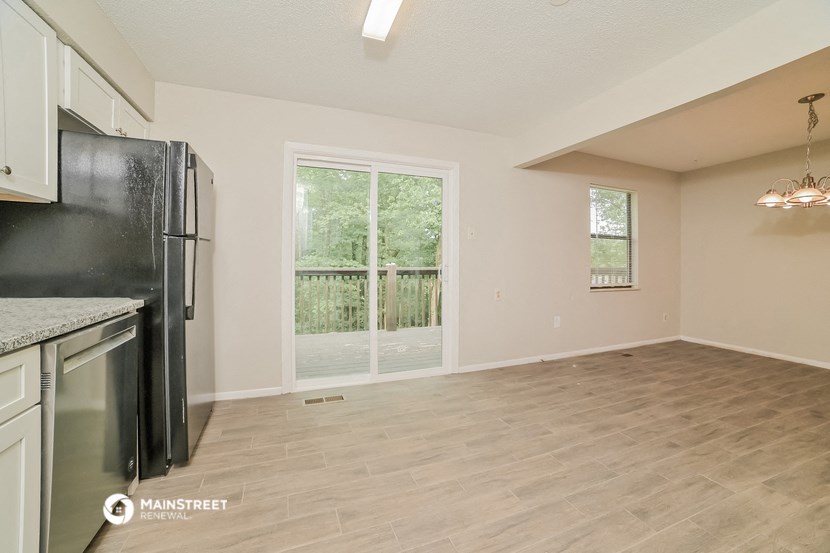 the spacious kitchen with stainless steel appliances and a large window