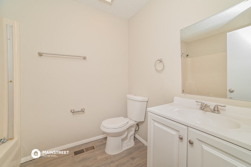 a bathroom with a toilet and a sink and a mirror