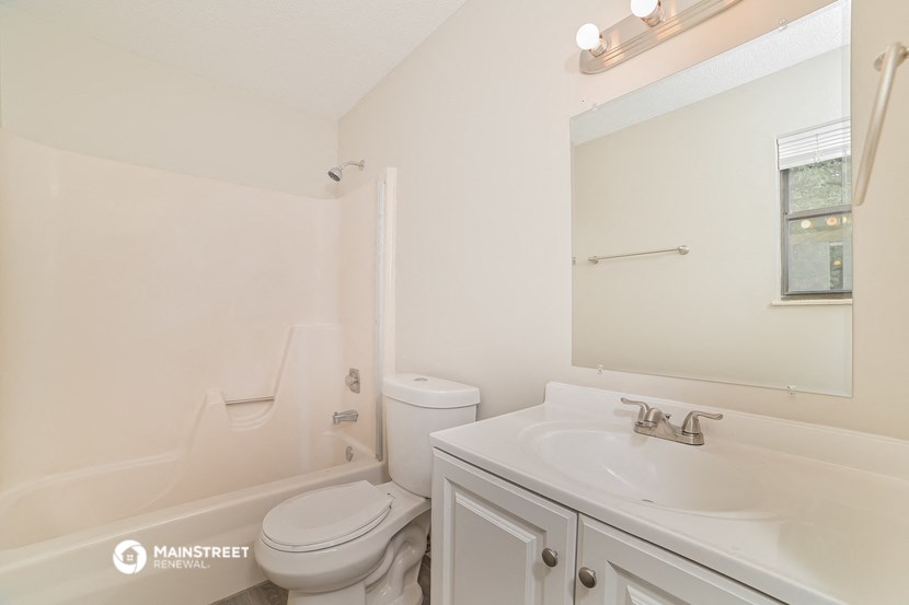 a bathroom with a sink toilet and a mirror