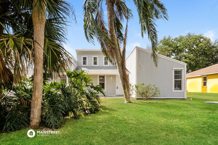 a white house with palm trees in front of it