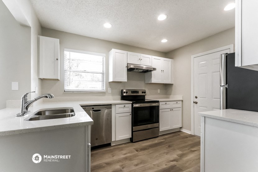 a kitchen with white cabinets and stainless steel appliances
