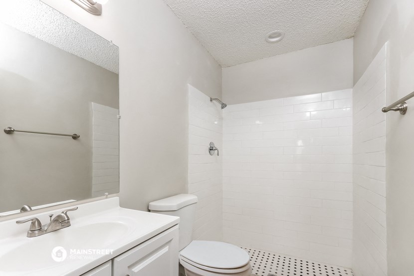 a white bathroom with a sink toilet and shower