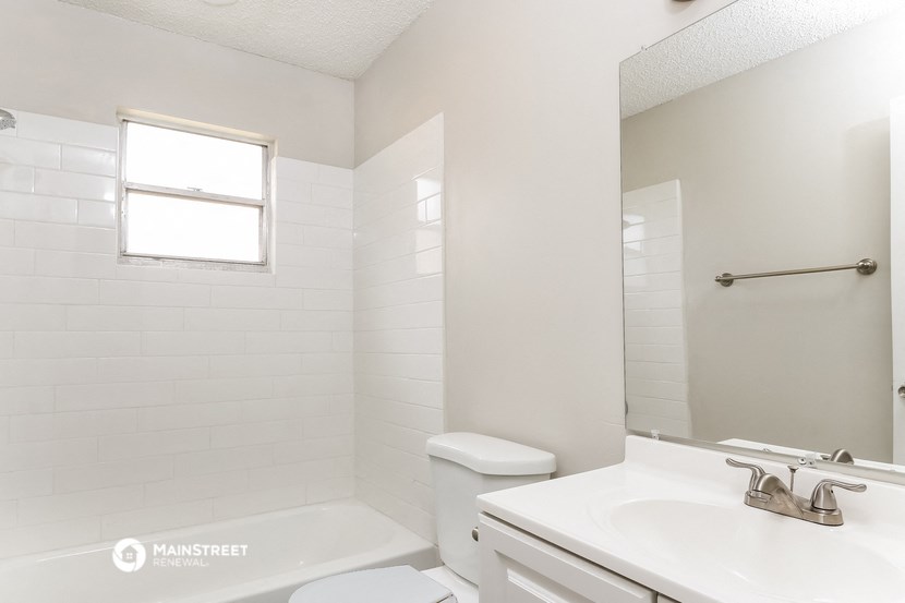 a white bathroom with a sink toilet and shower