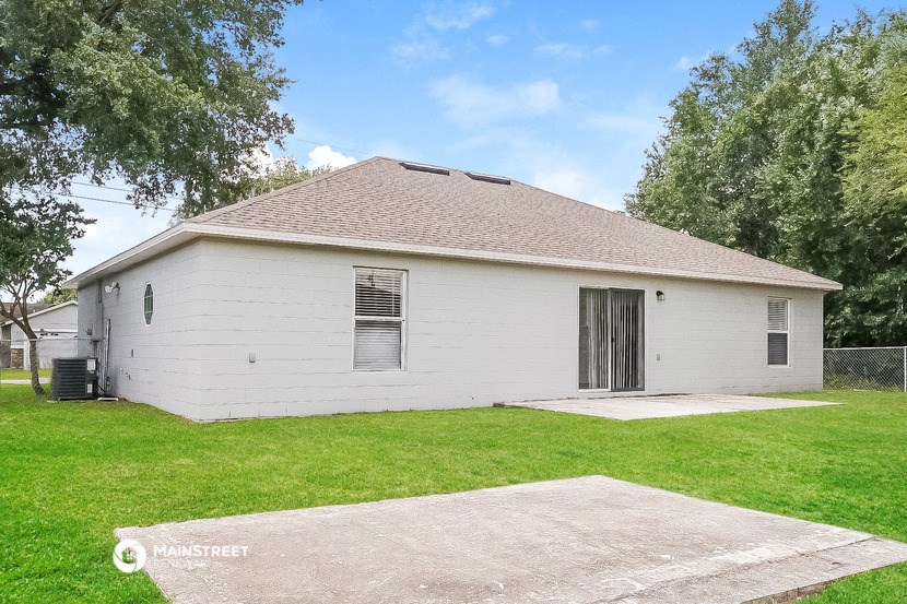 a small white house with a yard and a garage