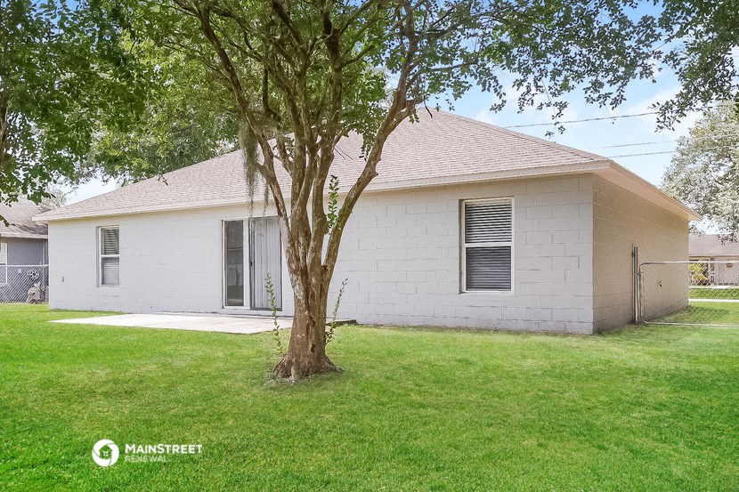a small white house with a tree in the yard