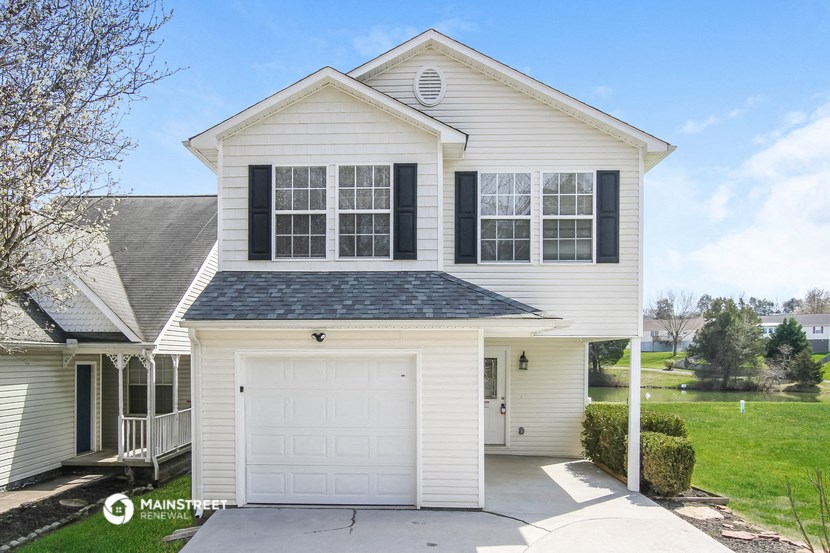 the front of a white house with a white garage door